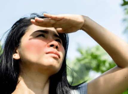 asian covering her face from direct sunlight